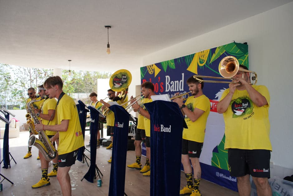 Baloo's Band con atriles bajo un porche, junto a la pancarta de la banda