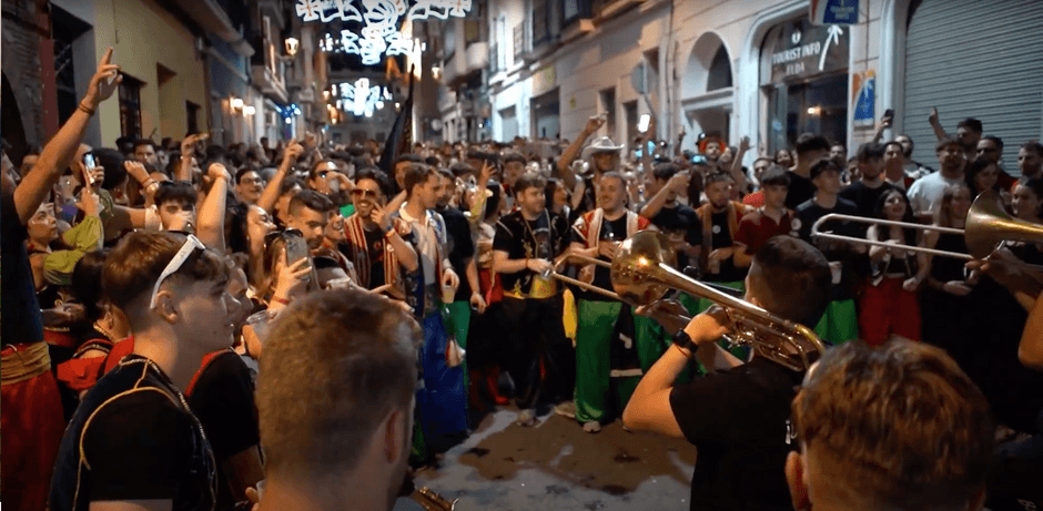 Calle llena de gente de noche alrededor de Baloo's Band en Moros y Cristianos